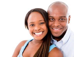 young couple facing forward with bright smiles 