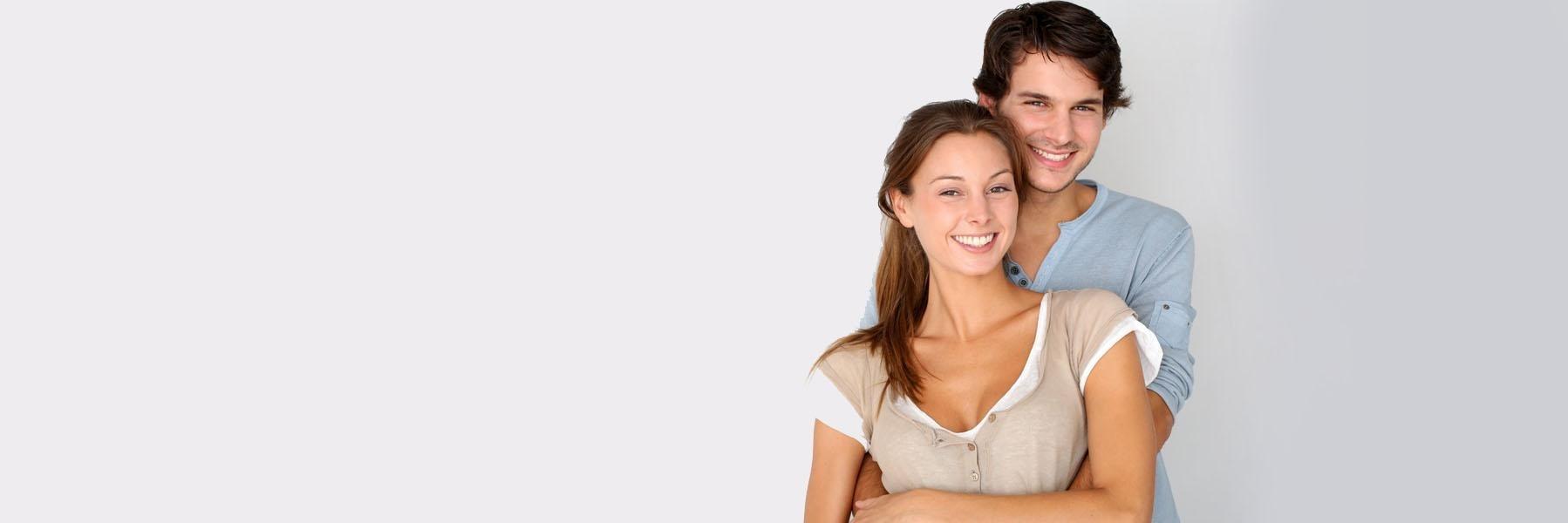 Young couple hugging & smiling