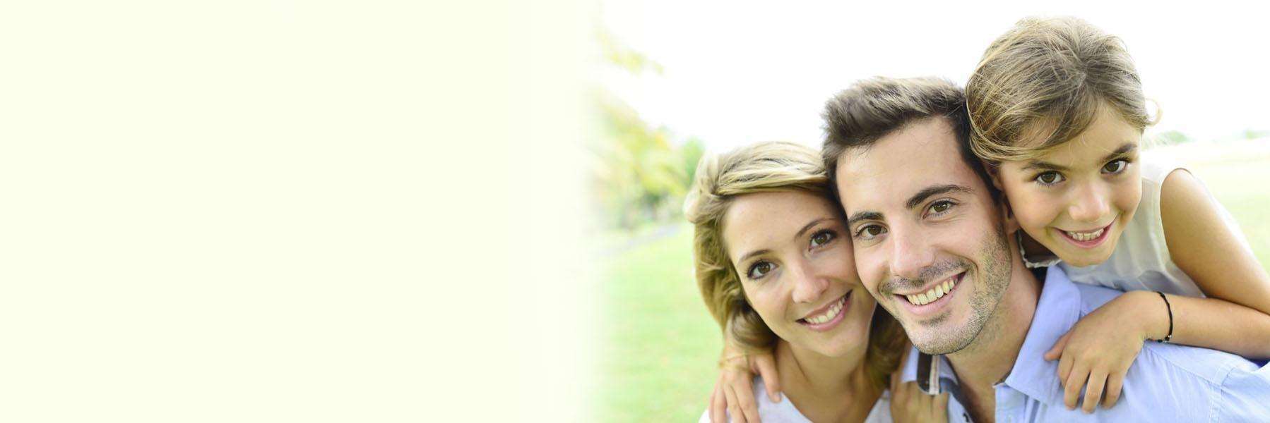 A happy family of three, consisting of a father, mother, and young daughter.