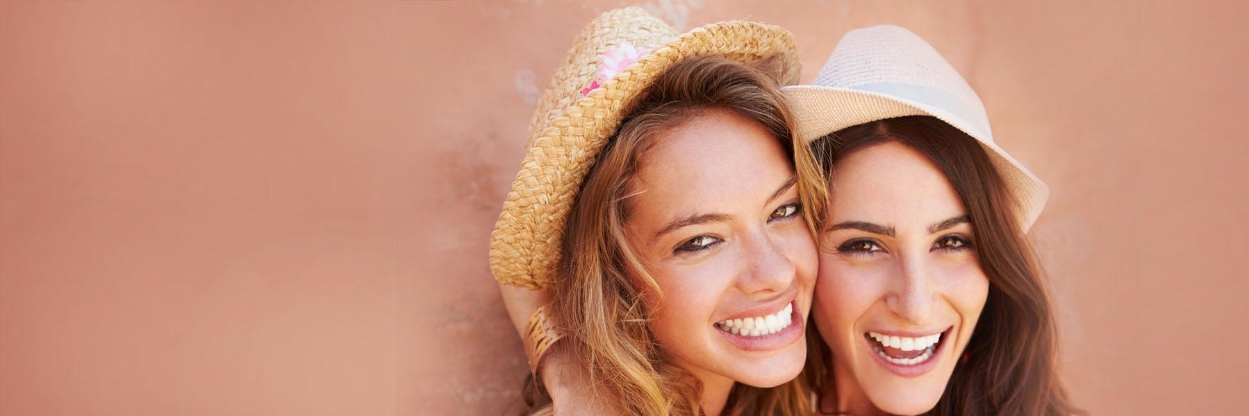 Women with hats smiling 