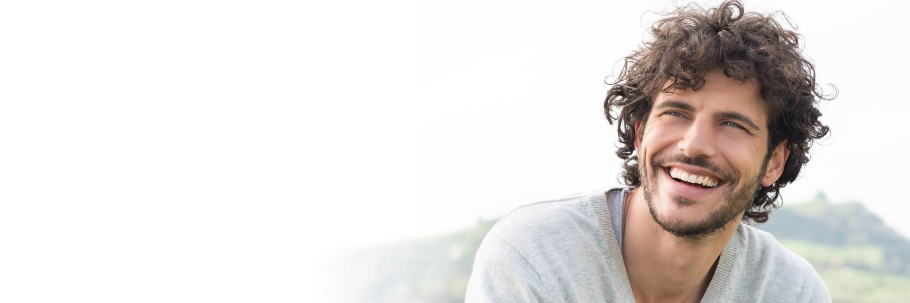 man with curly hair smiling 