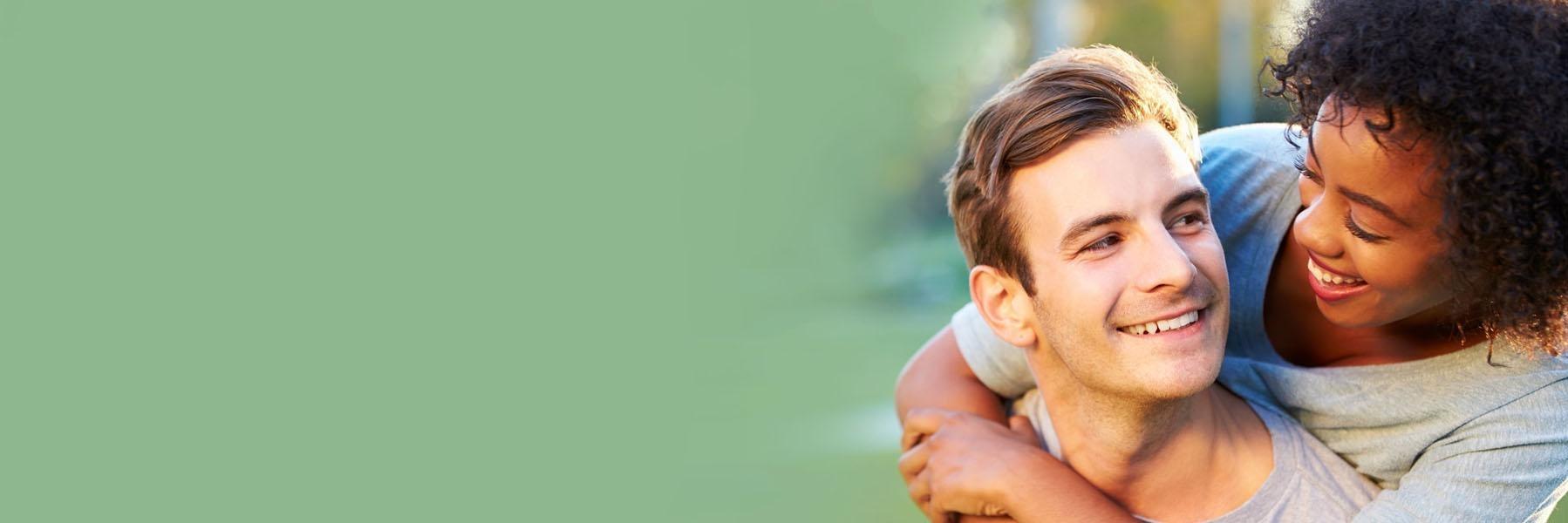 Young couple smiling & hugging 